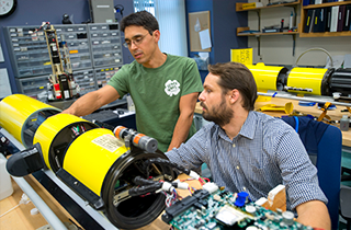 A professor and student studying an underwater glider at the Center for Ocean Observing Leadership 